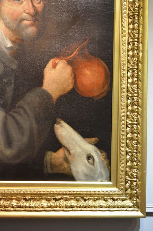 fig 1. An 18th-century oil portrait of a man holding a pitcher with a dog by his side, set within a heavily carved giltwood frame.