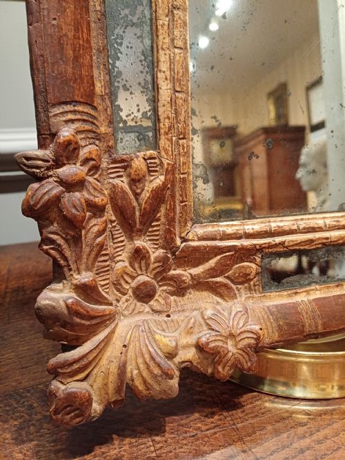 fig 1. A small rectangular French Regence carved wooden mirror featuring floral motifs and inset glass slips surrounding an aged central mirror plate.