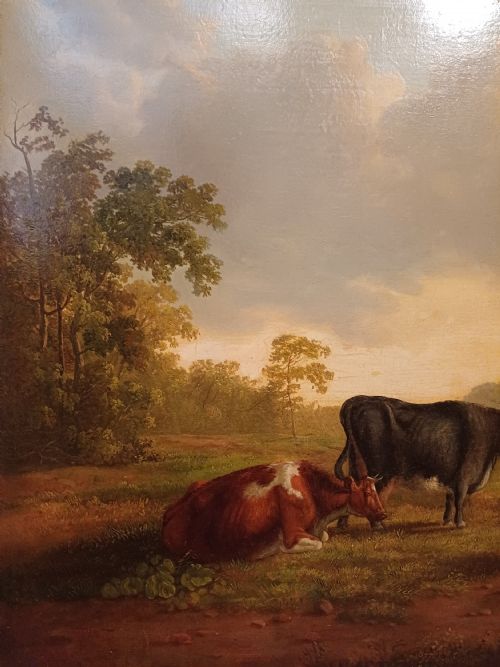 fig 1. A 19th-century oil painting depicting cattle and sheep resting in an open pastoral landscape beneath a cloud-filled sky, enclosed in an ornate gilded frame.