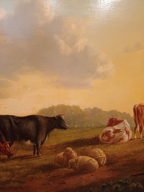 fig 2. A 19th-century oil painting depicting cattle and sheep resting in an open pastoral landscape beneath a cloud-filled sky, enclosed in an ornate gilded frame.