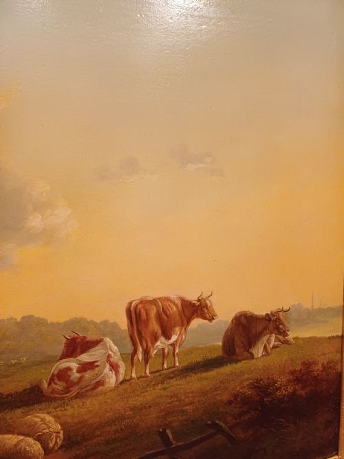 fig 3. A 19th-century oil painting depicting cattle and sheep resting in an open pastoral landscape beneath a cloud-filled sky, enclosed in an ornate gilded frame.