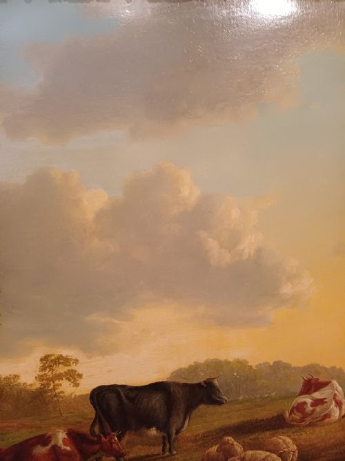 fig 4. A 19th-century oil painting depicting cattle and sheep resting in an open pastoral landscape beneath a cloud-filled sky, enclosed in an ornate gilded frame.