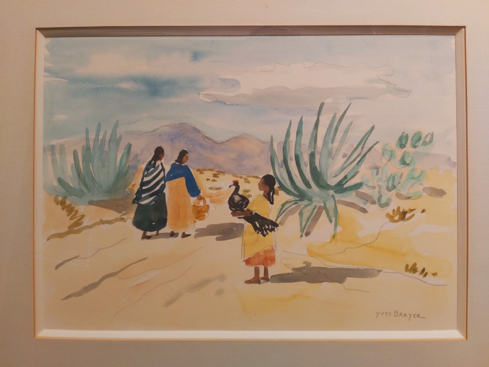 A framed watercolour painting depicting figures walking past agave plants in a desert landscape, presented in a gold-finished wooden frame with a cream mount. View VII