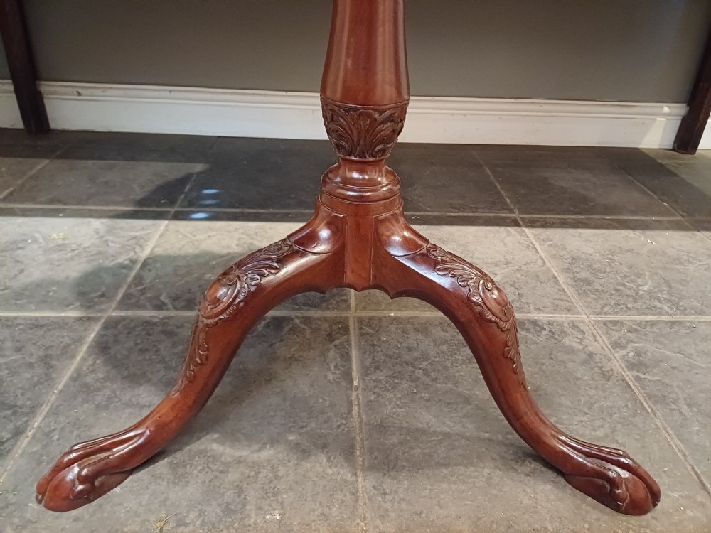 An 18th-century mahogany tilt-top table positioned vertically to display a carved piecrust border, turned pillar, and tripod cabriole legs. View III