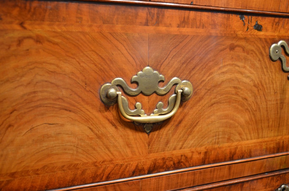 An 18th-century George I walnut chest on chest featuring tiered drawers with brass handles, featherbanded veneer, and bracket feet. View XVI