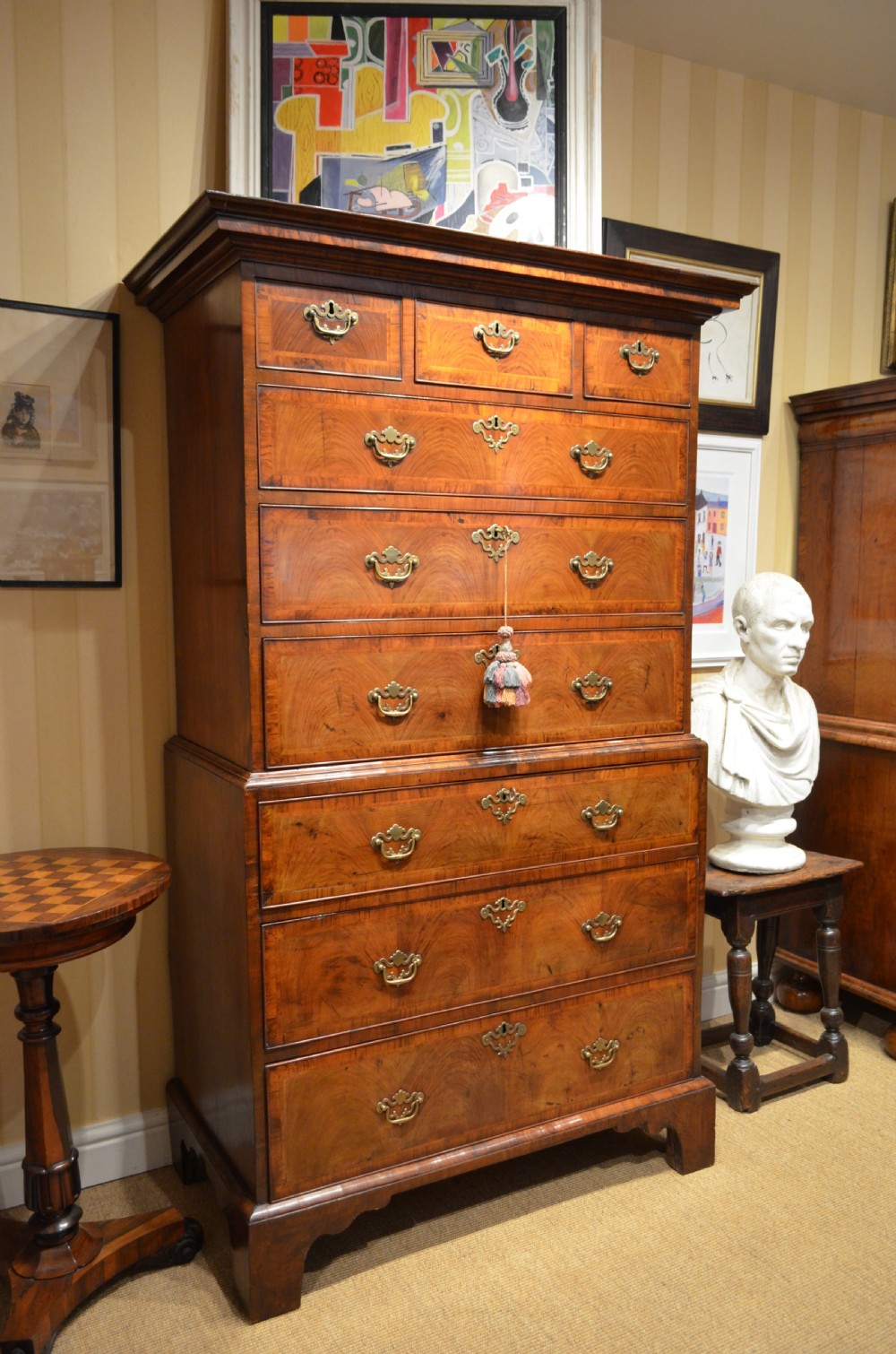 An 18th-century George I walnut chest on chest featuring tiered drawers with brass handles, featherbanded veneer, and bracket feet. View XXII