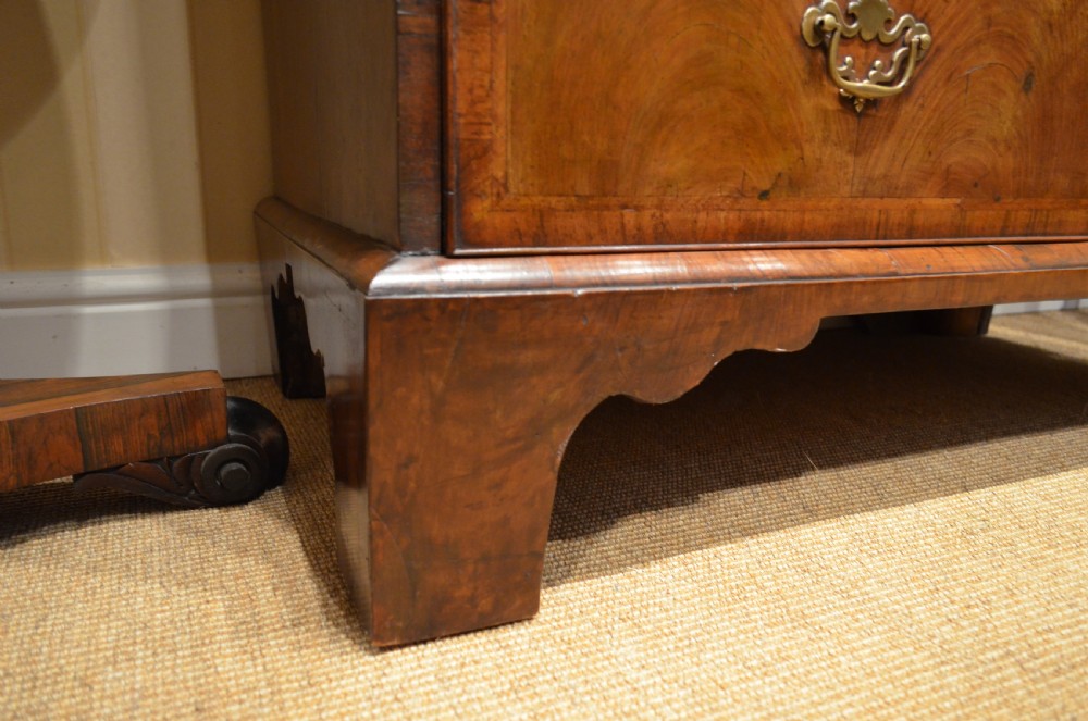 An 18th-century George I walnut chest on chest featuring tiered drawers with brass handles, featherbanded veneer, and bracket feet. View XXIII
