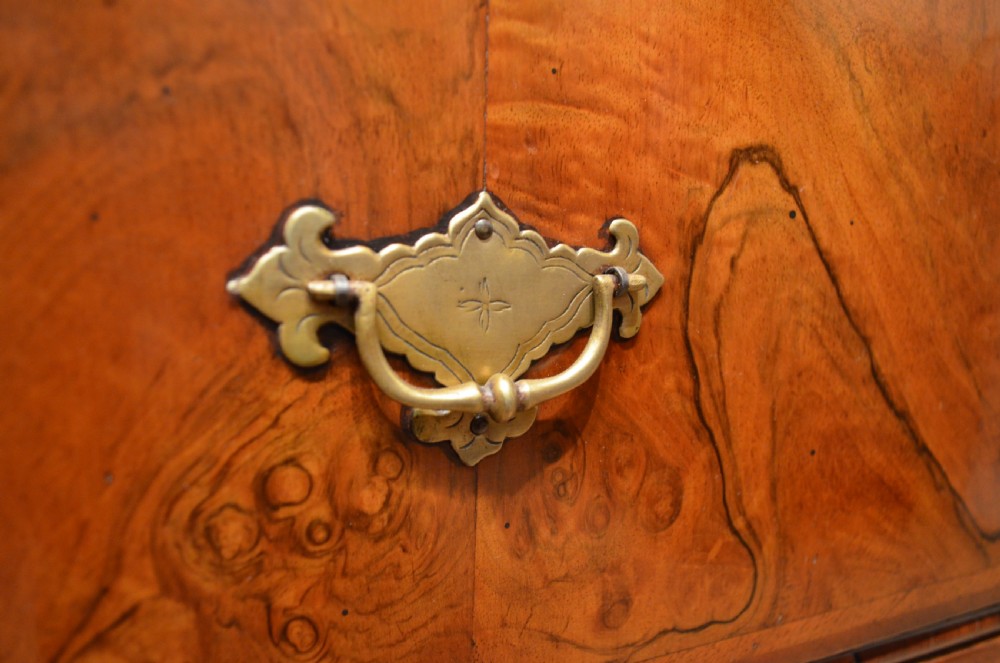 A two-section William and Mary walnut cabinet on chest featuring double doors with burr walnut panel veneers above a lower chest of drawers with turned bun feet. View XVIII