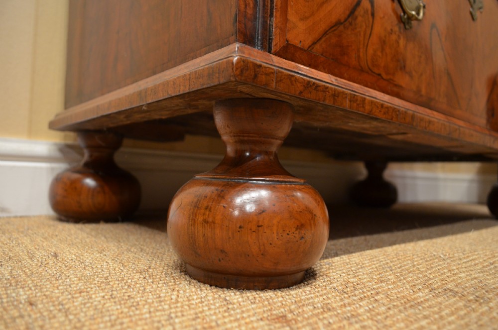 A two-section William and Mary walnut cabinet on chest featuring double doors with burr walnut panel veneers above a lower chest of drawers with turned bun feet. View XXX