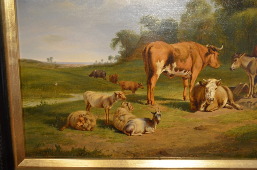 An antique framed Dutch pastoral oil painting depicting cattle, sheep, goats, a donkey, and figures in an open landscape under a cloud-filled sky. View II