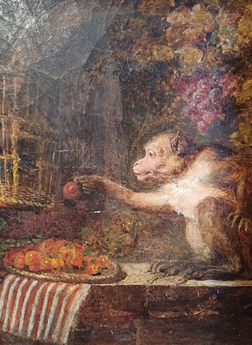 A 19th-century oil painting depicting a monkey beside fruit, enclosed within an ornate, hand-carved giltwood frame featuring oak leaf and acorn motifs. View II