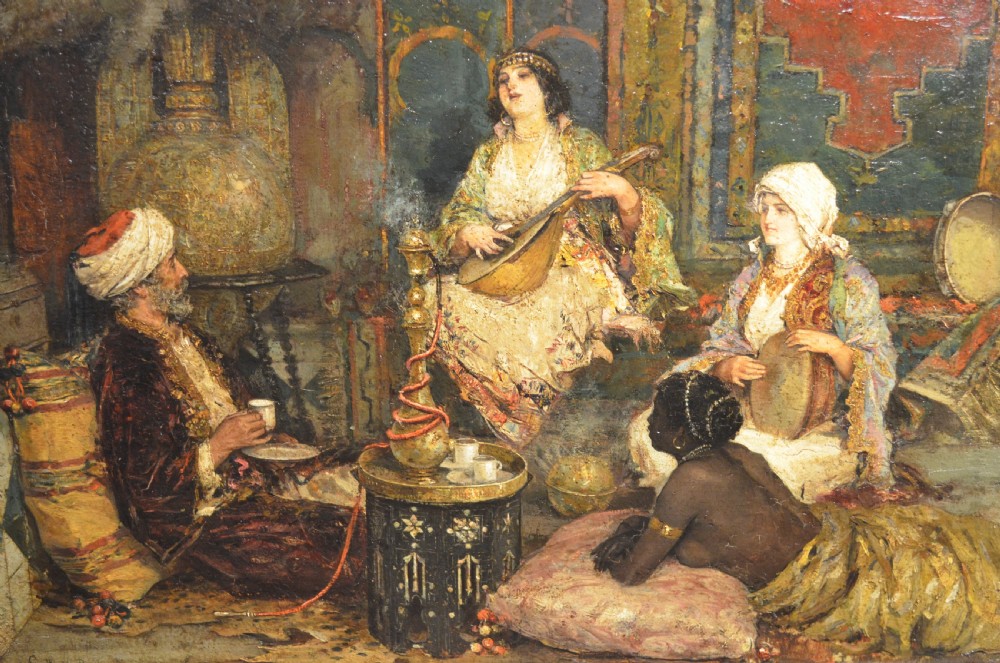 A framed 19th-century Orientalist oil painting on board featuring figures playing music and resting in a detailed interior scene. View IX