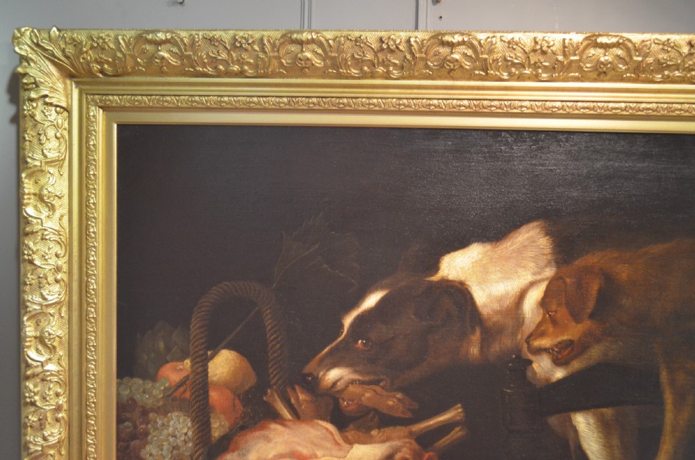 An oil painting depicting two dogs reaching into a woven basket containing meat and fruit, encased in an ornate gilded frame. View III