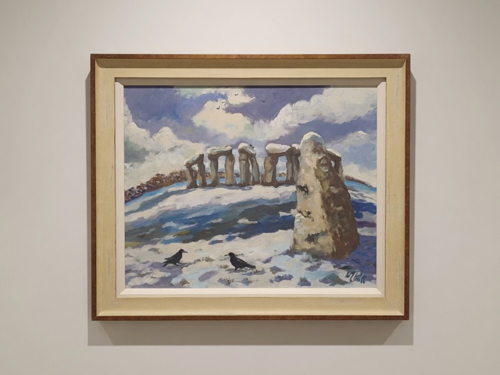A framed original oil painting depicting the Heel Stone and Stonehenge covered in snow under a cloudy sky with two crows in the foreground.