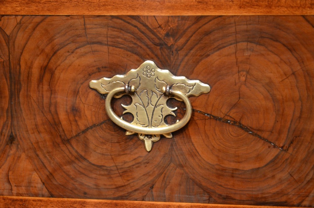 An antique William and Mary period walnut chest of drawers featuring geometric oyster veneer patterns, brass teardrop handles, keyhole escutcheons, and turned bun feet. View XI