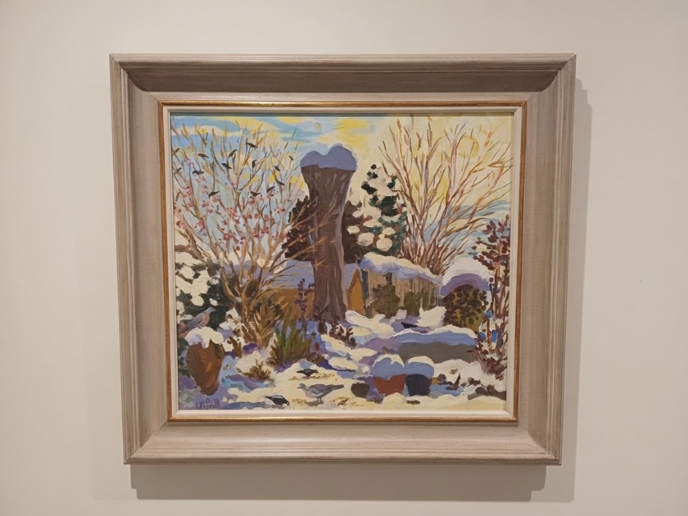 A framed square oil painting depicting a snow-covered winter garden with bare trees, birds, and pastel sky tones within a cream wooden frame.