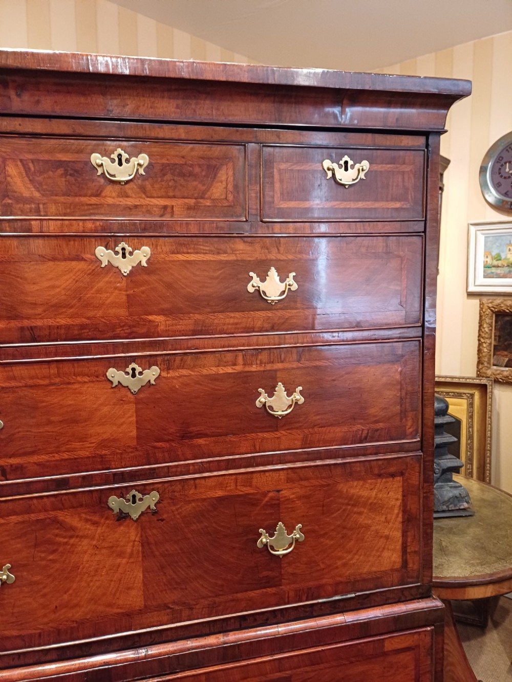 An early eighteenth-century walnut chest on chest featuring crossbanded drawers, brass handles, and bracket feet. View VI