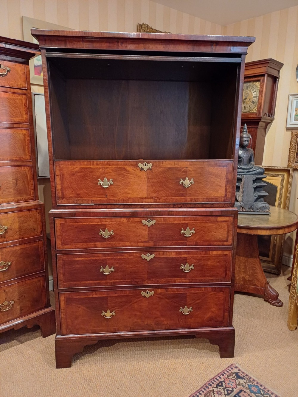 An early eighteenth-century walnut chest on chest featuring crossbanded drawers, brass handles, and bracket feet. View VII