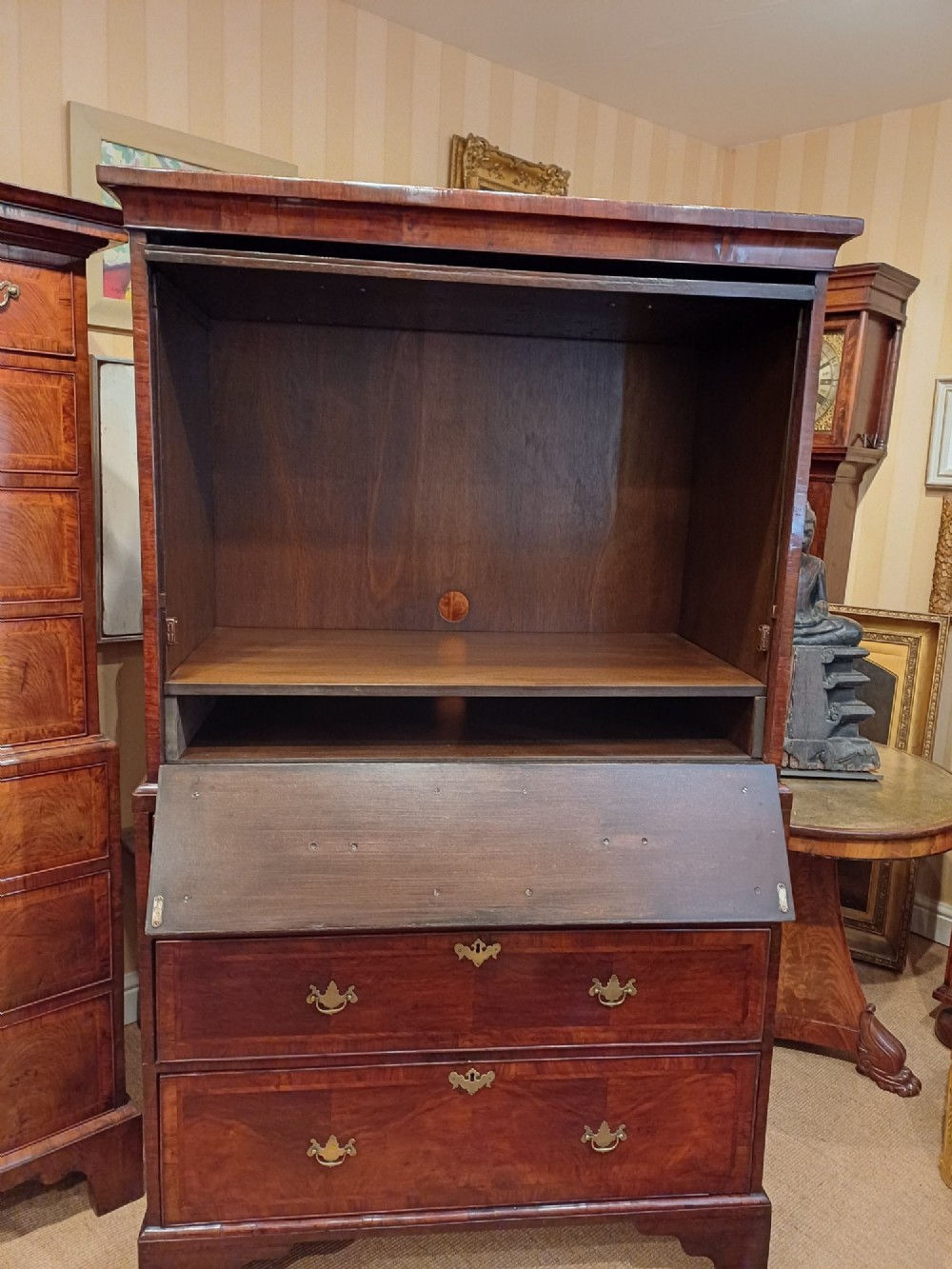 An early eighteenth-century walnut chest on chest featuring crossbanded drawers, brass handles, and bracket feet. View IX