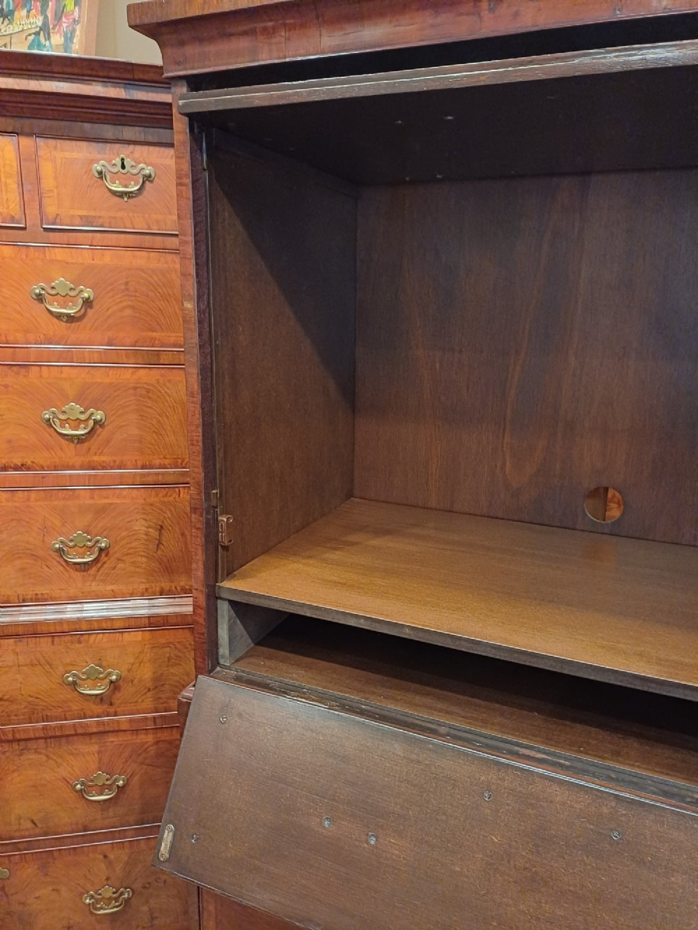 An early eighteenth-century walnut chest on chest featuring crossbanded drawers, brass handles, and bracket feet. View X