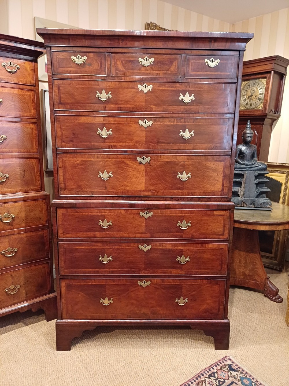 An early eighteenth-century walnut chest on chest featuring crossbanded drawers, brass handles, and bracket feet. View XIII