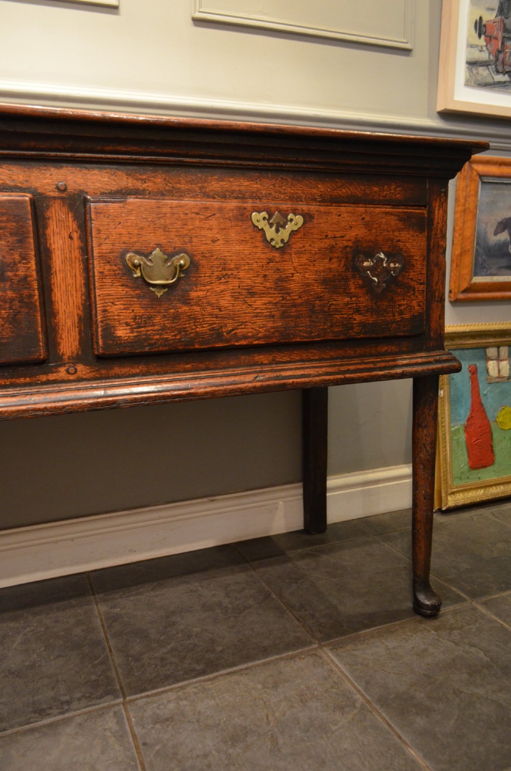 An 18th-century George III oak dresser base featuring three drawers with decorative brass handles and supported on slender legs with pad feet. View IV