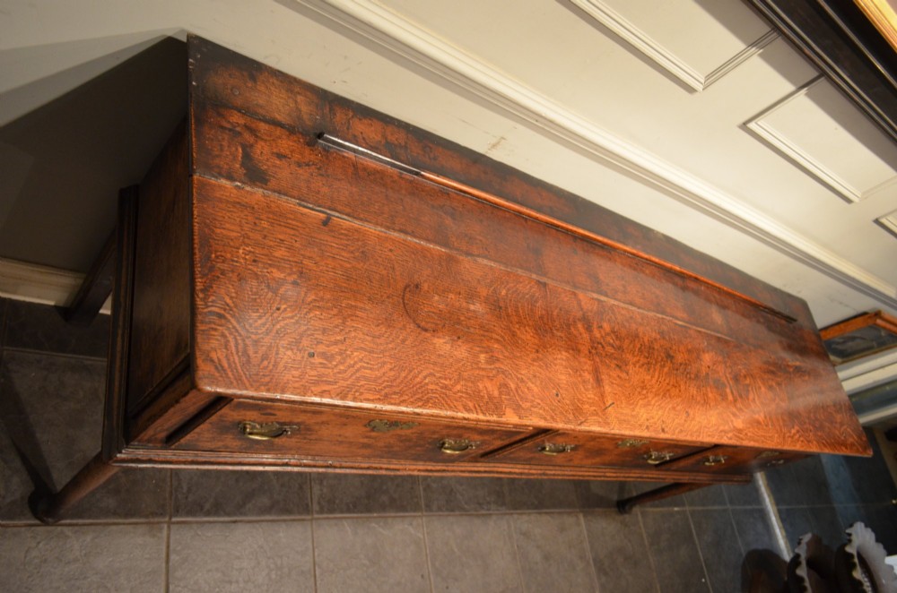An 18th-century George III oak dresser base featuring three drawers with decorative brass handles and supported on slender legs with pad feet. View VIII