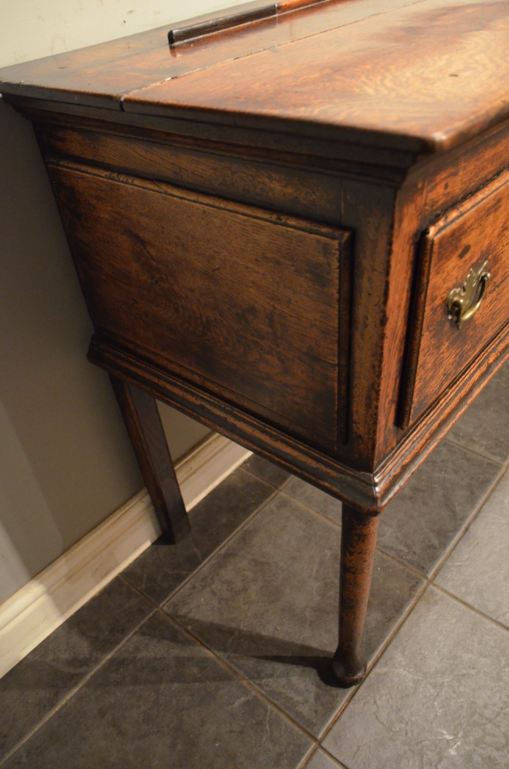 An 18th-century George III oak dresser base featuring three drawers with decorative brass handles and supported on slender legs with pad feet. View X