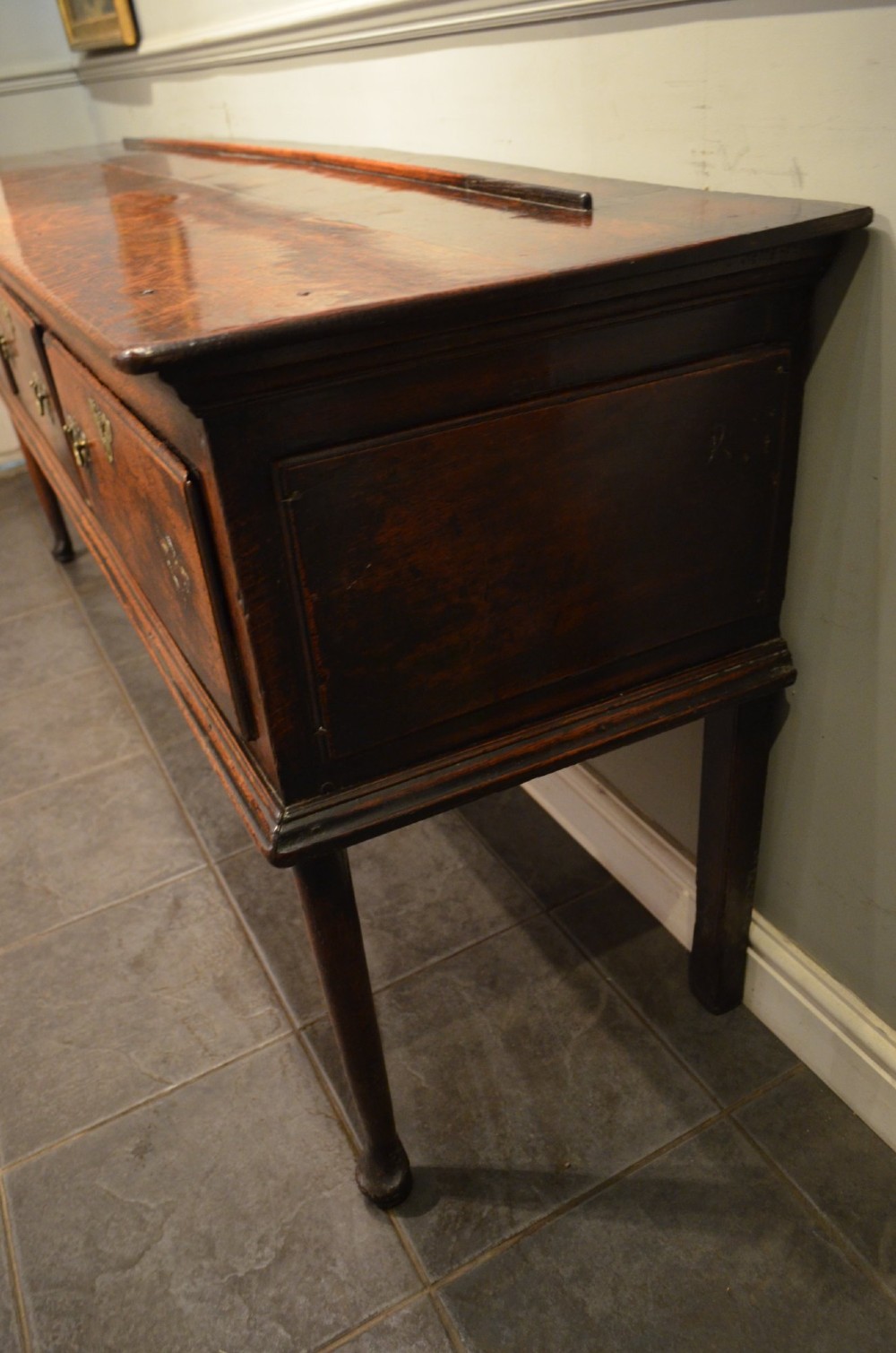 An 18th-century George III oak dresser base featuring three drawers with decorative brass handles and supported on slender legs with pad feet. View XI
