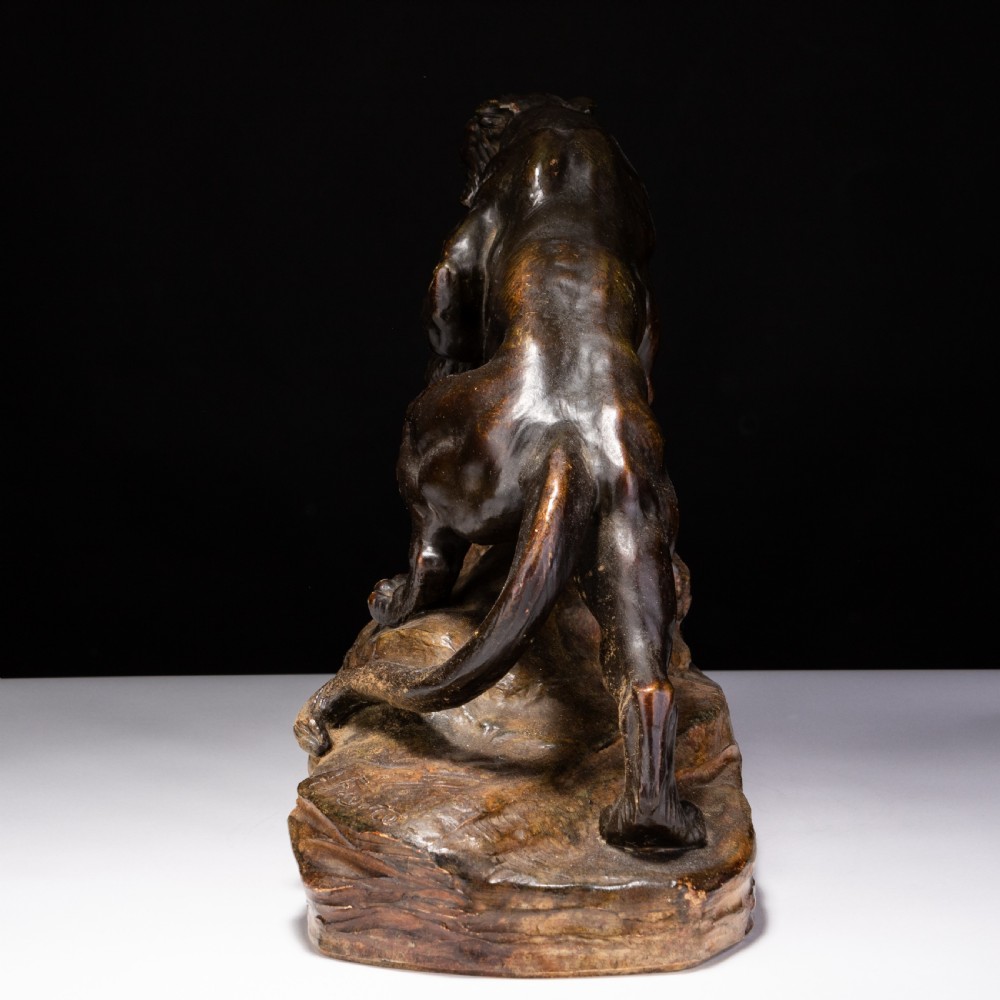A dark brown patinated ceramic sculpture depicting a roaring tiger poised on a rocky base in the Art Deco style. View IV