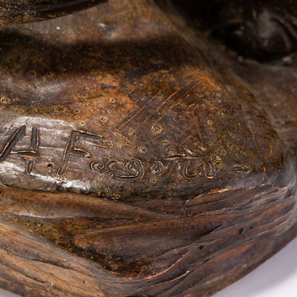 A dark brown patinated ceramic sculpture depicting a roaring tiger poised on a rocky base in the Art Deco style. View V