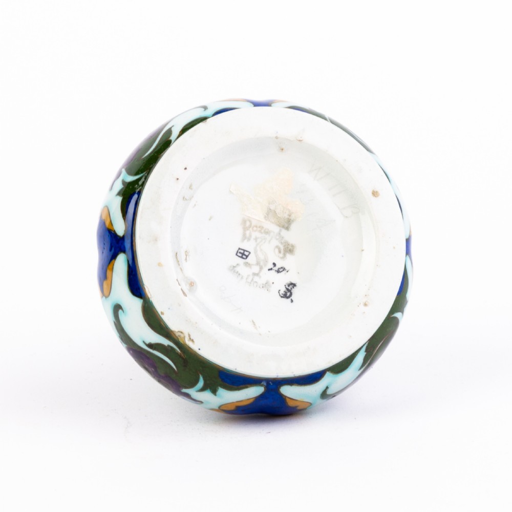 A squat, bulbous ceramic vase featuring an elongated neck, painted with polychrome Art Nouveau floral patterns in shades of blue, turquoise, orange, and purple against a white glaze. View IV