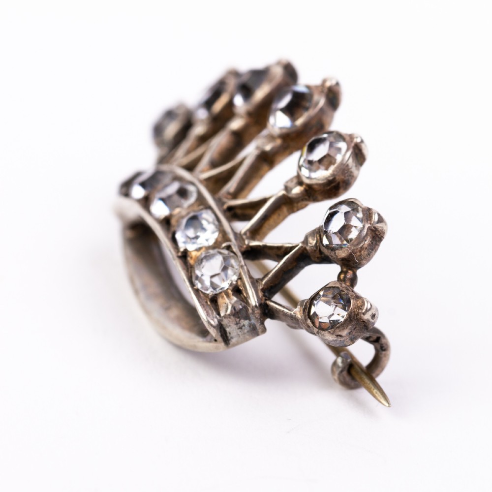 A Victorian silver brooch designed in the shape of a crown and set with round clear paste stones along the band and points. View III