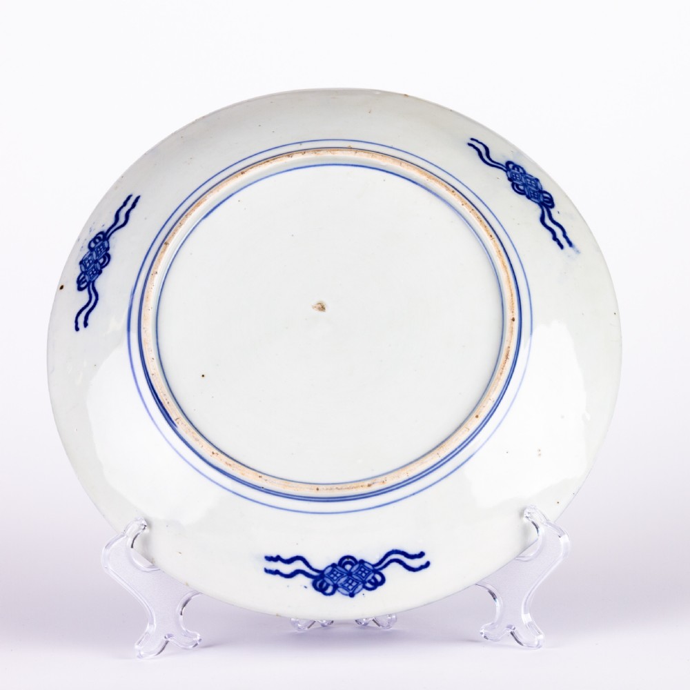 A circular blue and white Chinese porcelain display plate painted with Foo dogs and peony flowers encircled by a decorative patterned border. View II