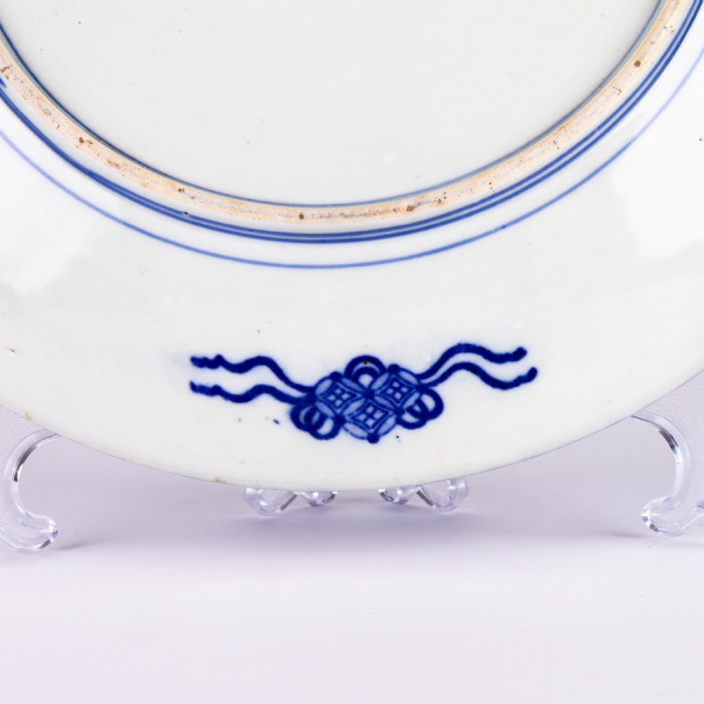 A circular blue and white Chinese porcelain display plate painted with Foo dogs and peony flowers encircled by a decorative patterned border. View IV