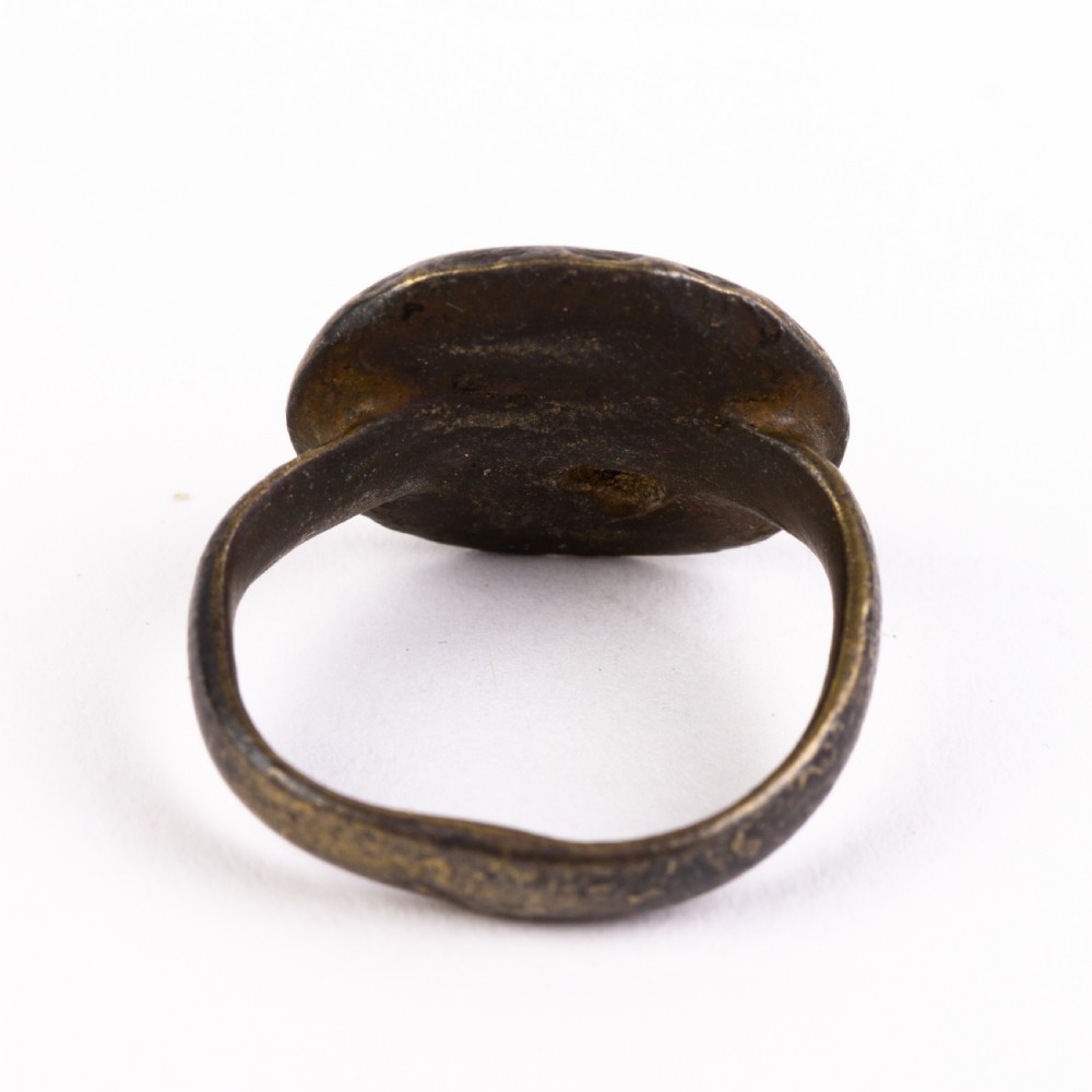 A dark patinated bronze signet ring featuring a rounded bezel hand-engraved with an eight-pointed star motif on a narrow metal band. View II
