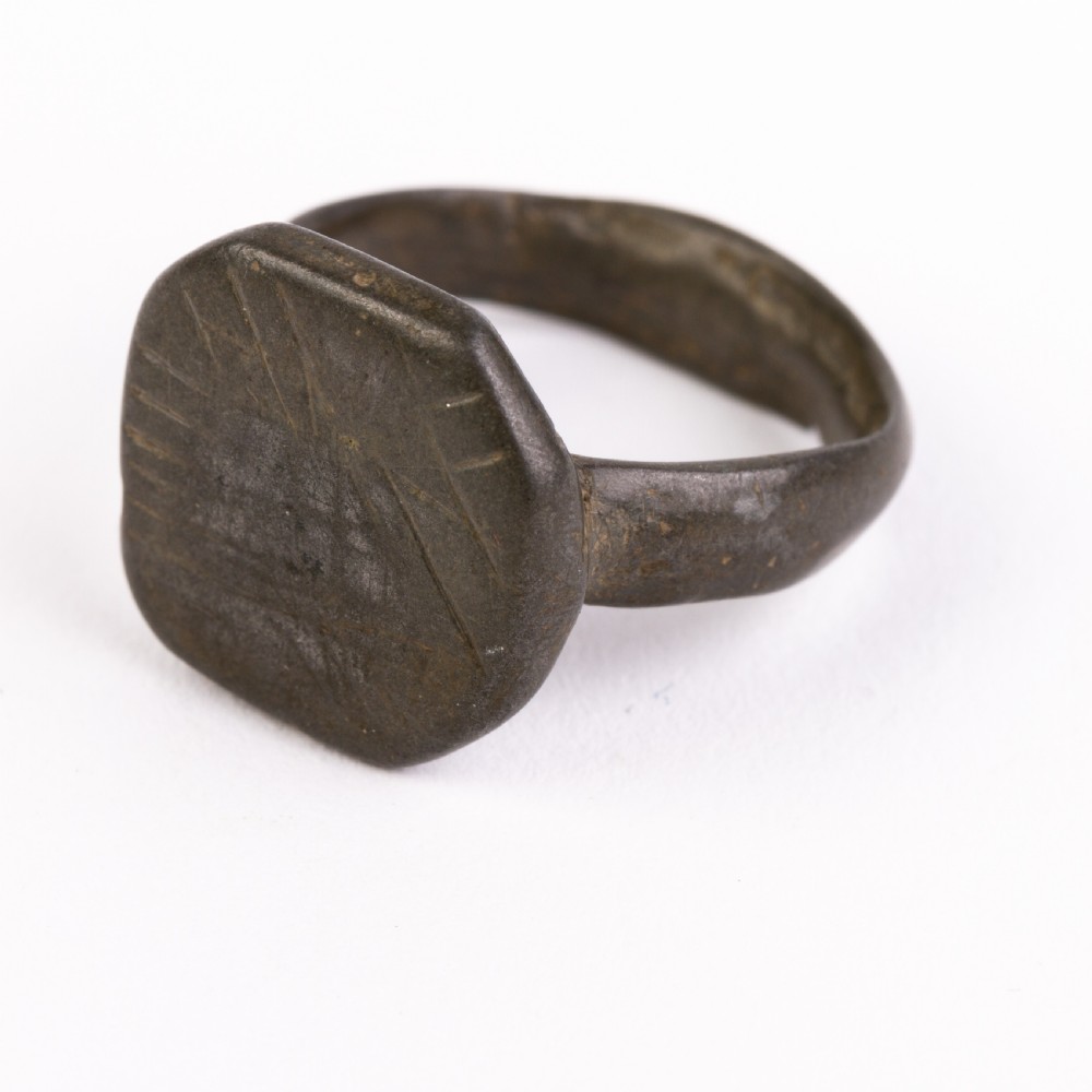 A dark patinated bronze signet ring featuring an octagonal bezel with faint geometric hand-engraved markings. View III
