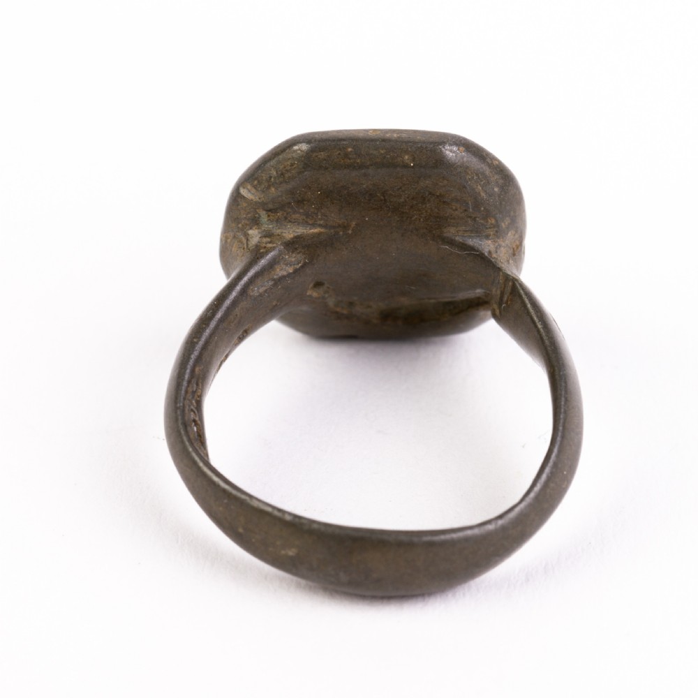 A dark patinated bronze signet ring featuring an octagonal bezel with faint geometric hand-engraved markings. View IV