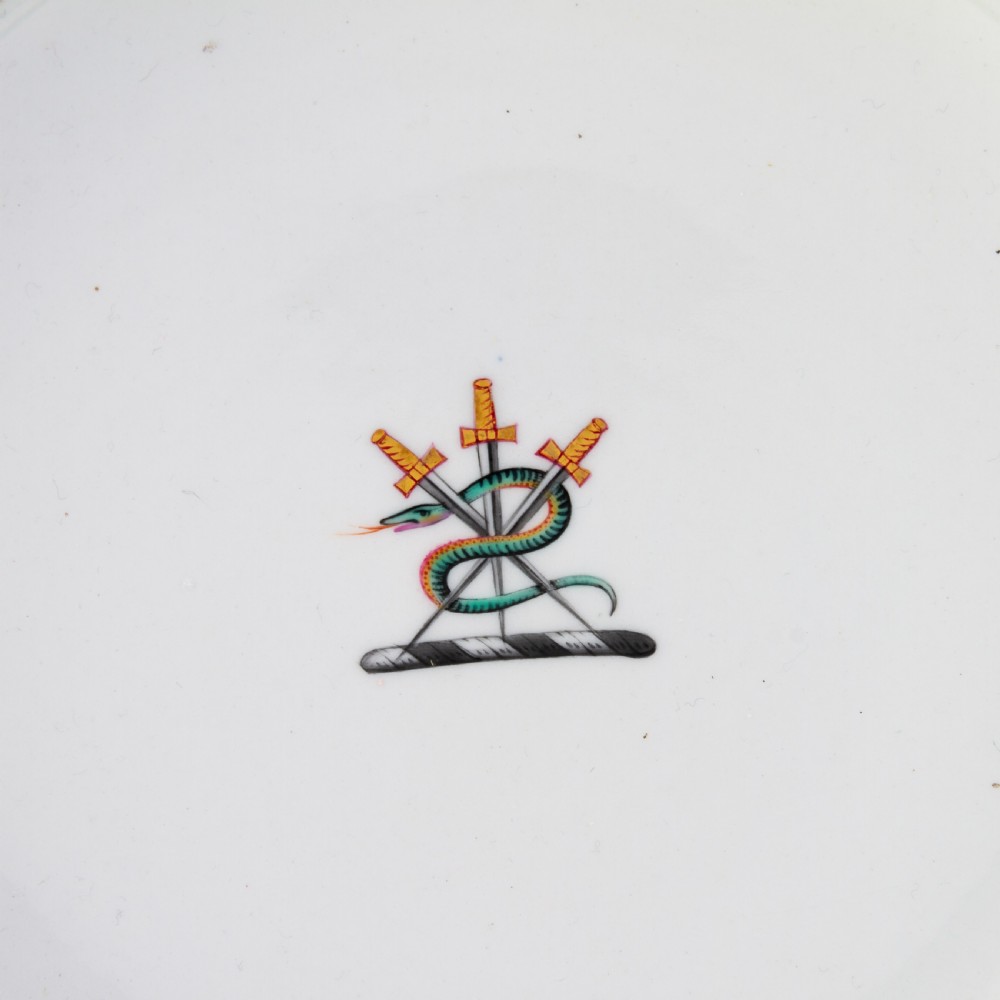 A Regency period Flight Barr and Barr porcelain plate featuring a green border, a gadrooned gilt rim, and a central hand-painted crest with three swords and a serpent. View IV