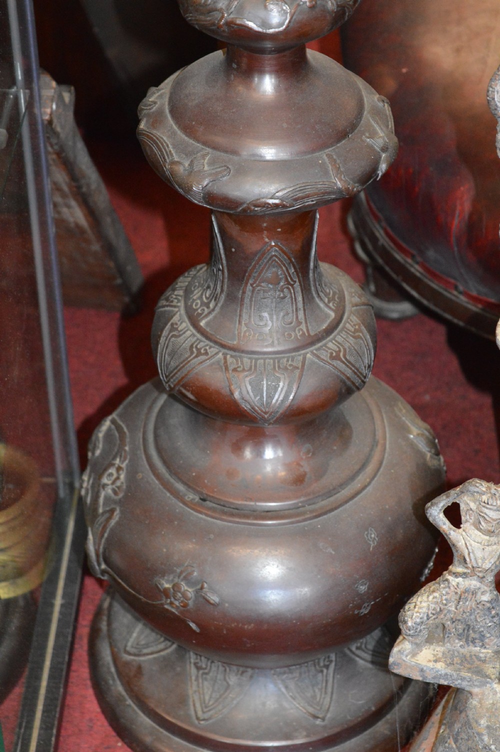 A tall 19th-century Chinese cast bronze sectional jardiniere stand featuring relief carvings of dragons and floral patterns on a tiered bulbous base. View III