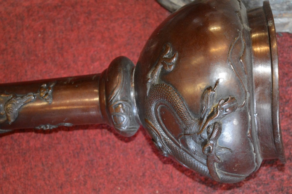 A tall 19th-century Chinese cast bronze sectional jardiniere stand featuring relief carvings of dragons and floral patterns on a tiered bulbous base. View VIII