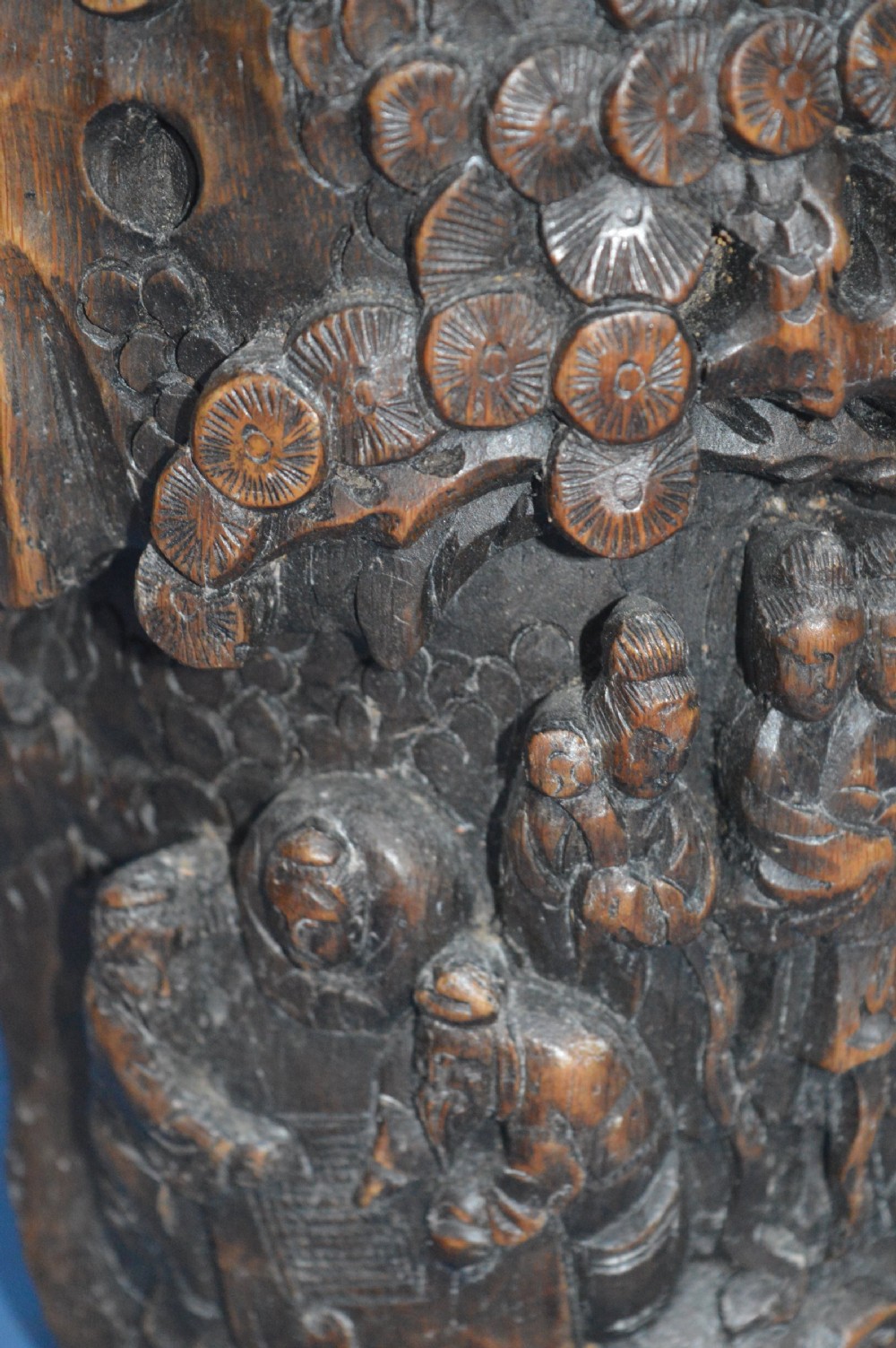A late nineteenth-century hand-carved dark brown Chinese bamboo brush pot depicting figures and pine trees in high relief. View II