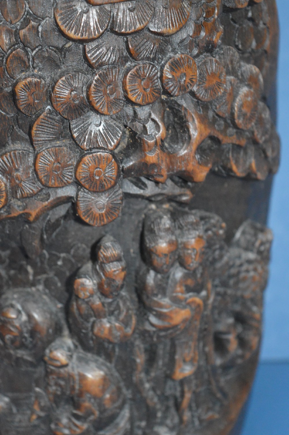 A late nineteenth-century hand-carved dark brown Chinese bamboo brush pot depicting figures and pine trees in high relief. View III