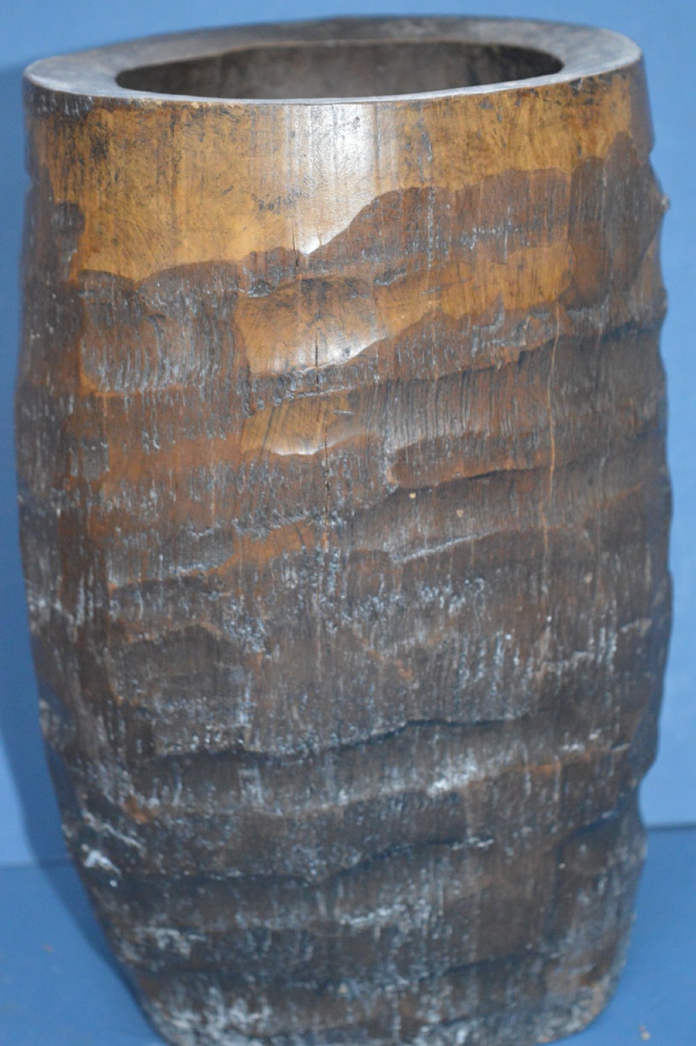 A late nineteenth-century hand-carved dark brown Chinese bamboo brush pot depicting figures and pine trees in high relief. View V