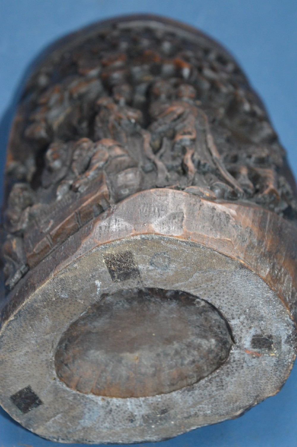 A late nineteenth-century hand-carved dark brown Chinese bamboo brush pot depicting figures and pine trees in high relief. View VII