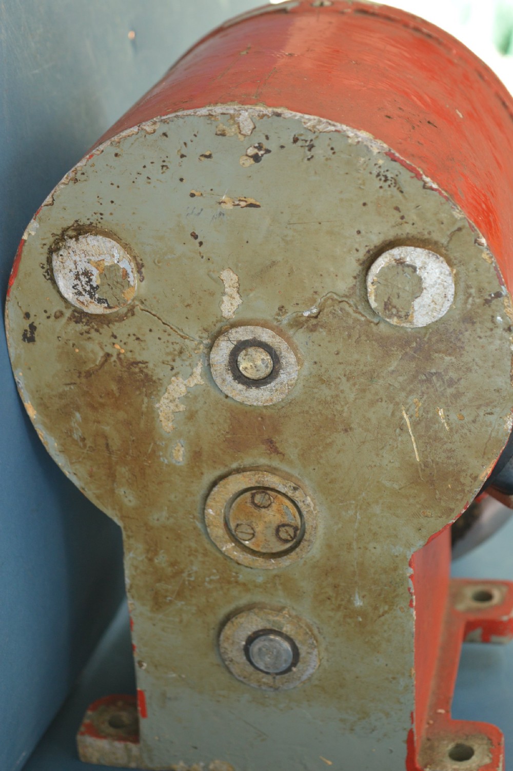A mid-20th-century red and black painted metal ship engine order telegraph featuring a circular dial with ahead and astern markings behind glass and a four-spoke control wheel. View VI