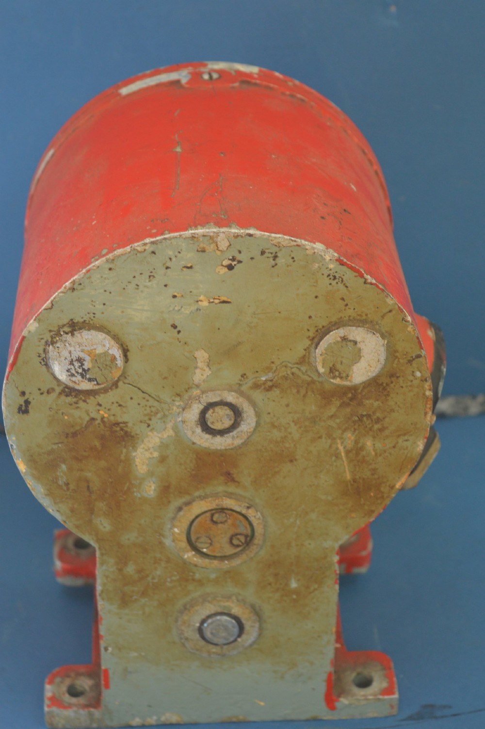 A mid-20th-century red and black painted metal ship engine order telegraph featuring a circular dial with ahead and astern markings behind glass and a four-spoke control wheel. View VII