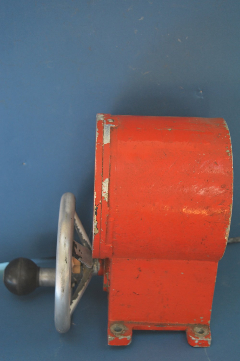 A mid-20th-century red and black painted metal ship engine order telegraph featuring a circular dial with ahead and astern markings behind glass and a four-spoke control wheel. View VIII