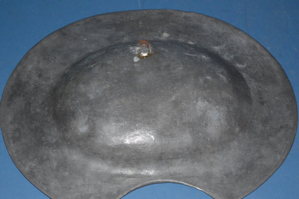 A 19th-century French pewter oval barber bowl with a crescent neck cut-out, embossed rim lettering, and a central relief scene. View IX