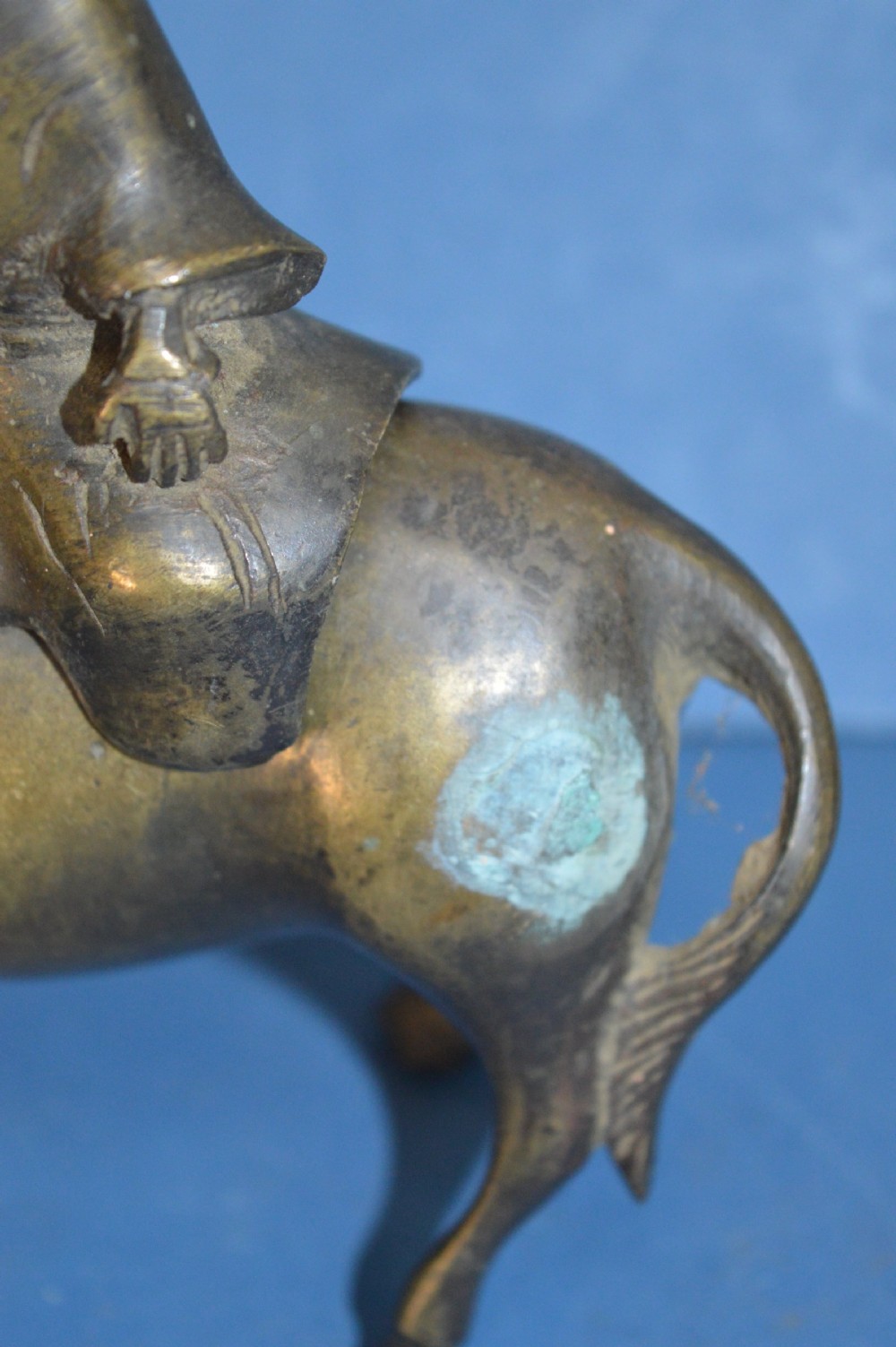 A late 19th-century cast bronze censer depicting a man dressed in robes seated astride a horned ox or water buffalo. View V